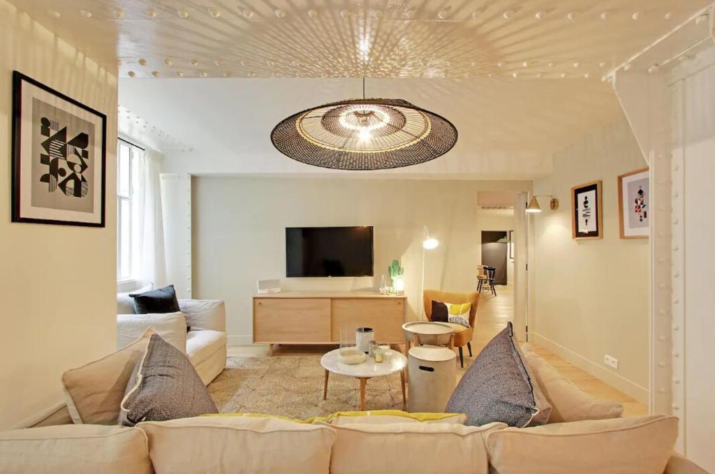 un salon avec un canapé et une télévision dans l'établissement 2 appartements en 1 - Superbe logement près du Louvre l 12P, à Paris