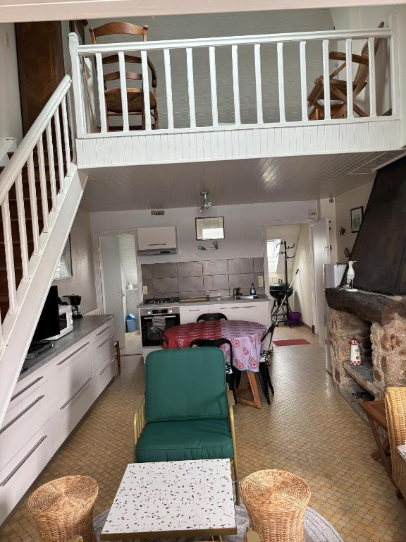 un salon avec un escalier et une cuisine dans l'établissement Studio les Mouettes, à Perros-Guirec