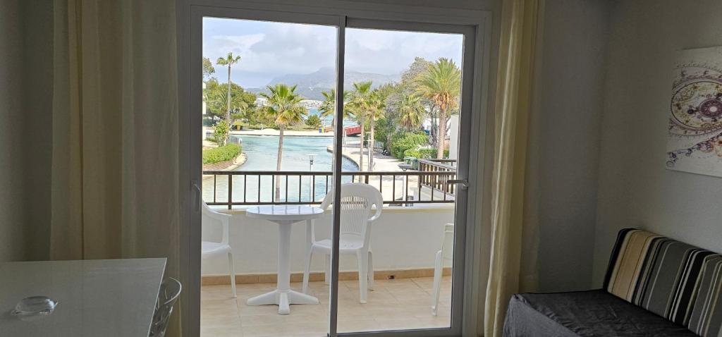 a room with a balcony with a view of a pool at Venecia Apartments in Port d'Alcudia