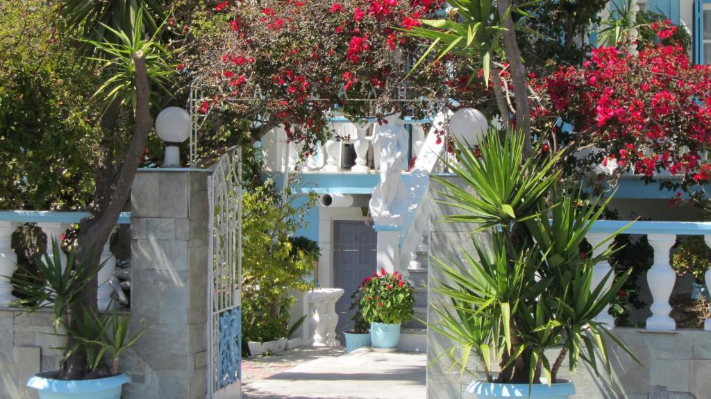 a white building with plants in front of it at Sandalis Hotel in Pythagoreio