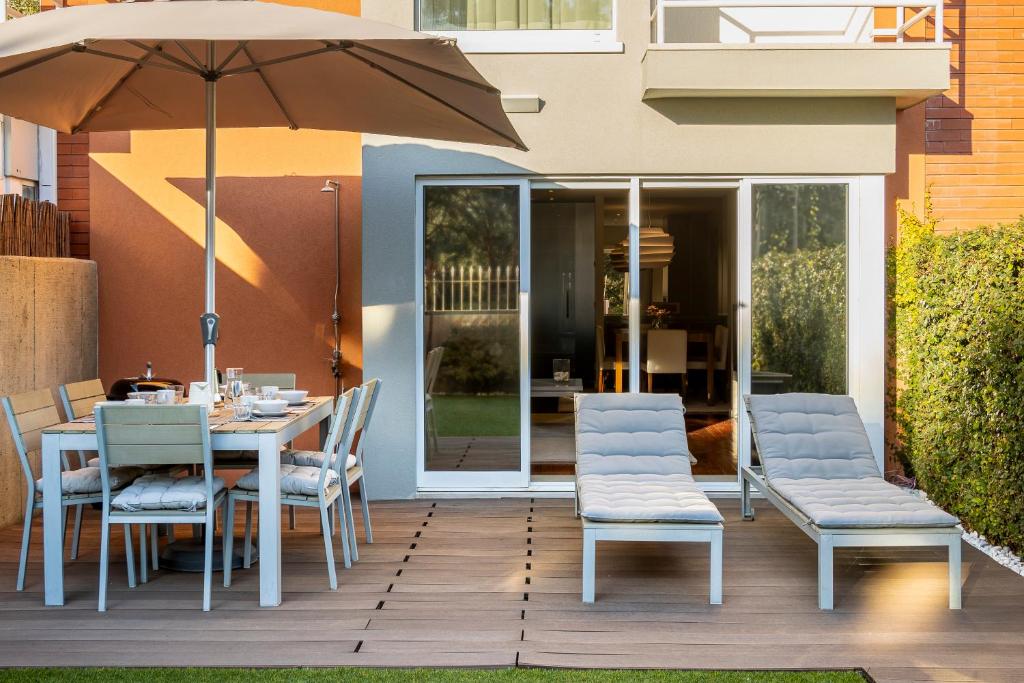 a table and chairs with an umbrella on a patio at Front Beach Villa Cabedelo in Viana do Castelo