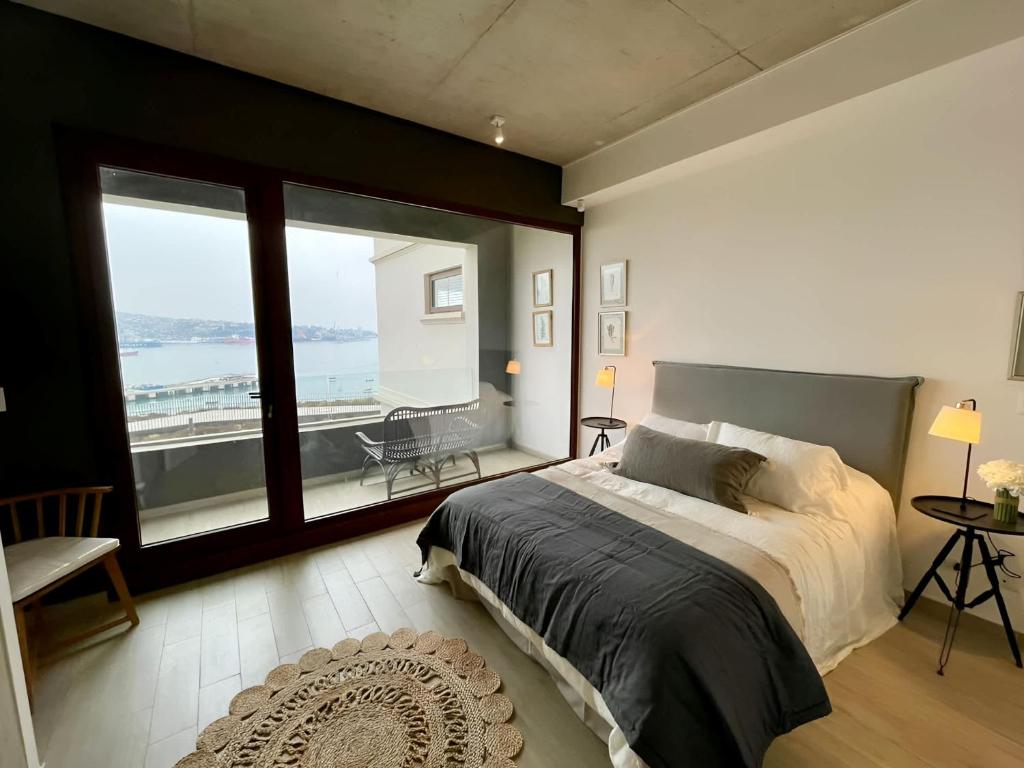 a bedroom with a large bed and a large window at HOM I Duplex en Mejor Vista de Valparaiso y Parking in Valparaíso