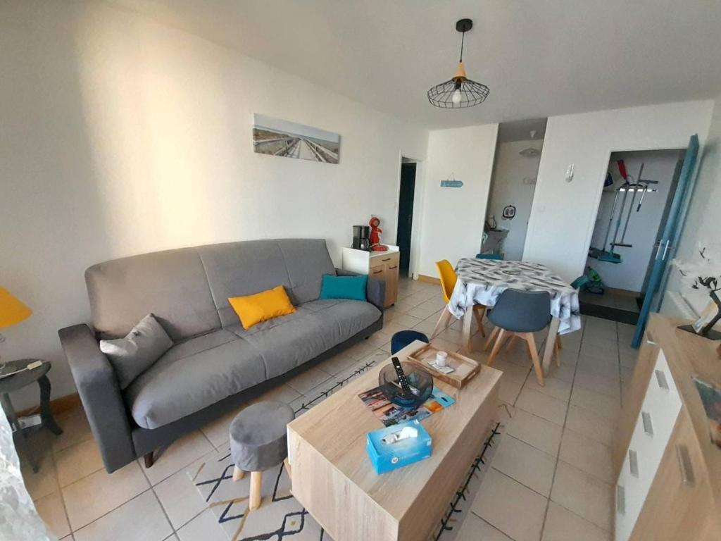 un salon avec un canapé et une table dans l'établissement Charmant T2 rénové avec loggia, proche mer et pistes cyclables à Saint-Hilaire-de-Riez - FR-1-324A-57, à Saint-Hilaire-de-Riez