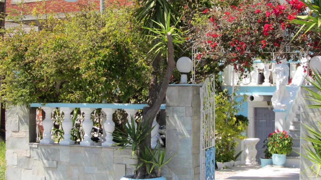 a house with a white fence and plants at Sandalis Hotel in Pythagoreio