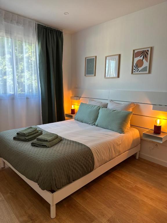 a bedroom with a bed with two towels on it at Entre Nantes et aéroport - Arrivée autonome 24h sur 24h in La Montagne