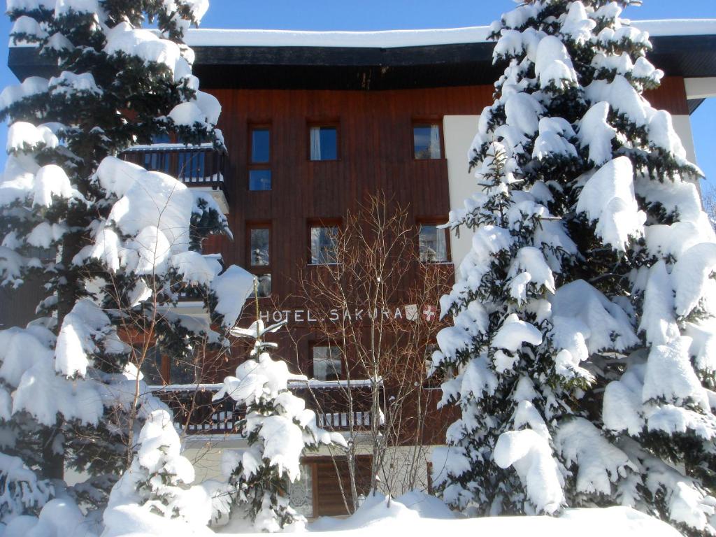 a snow covered tree in front of a building at Résidence Studio Sakura in Val-d'Isère