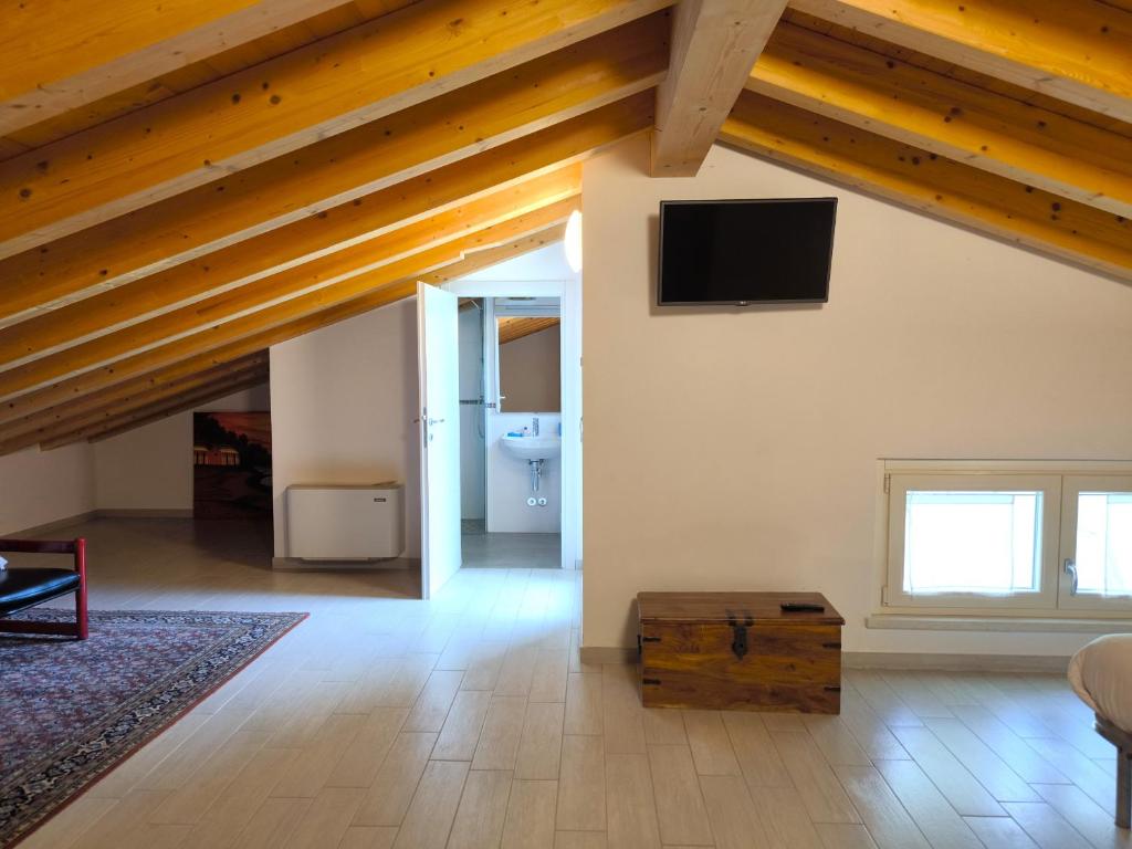 salon z drewnianymi sufitami i telewizorem w obiekcie Residenza Pastrengo w mieście Pastrengo