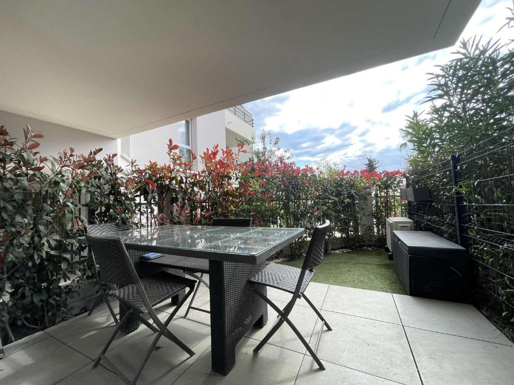 une table et des chaises sur une terrasse avec un jardin dans l'établissement Charmant 2P climatisé avec terrasse et jardin, centre-ville Le Lavandou - FR-1-308-187, au Lavandou
