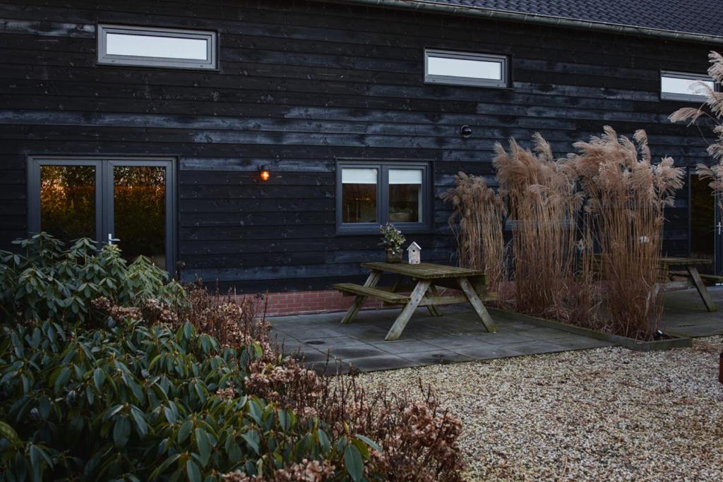 een houten picknicktafel voor een huis bij Troch & Foarút in Bakkeveen