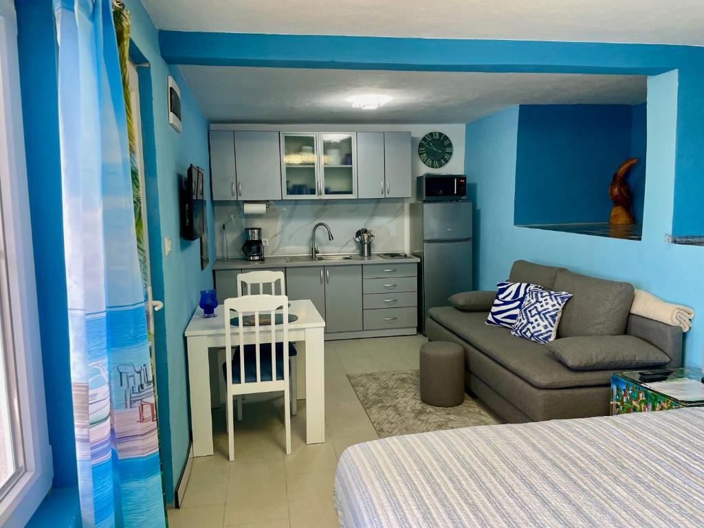 eine kleine Küche und ein Wohnzimmer mit einem Sofa und einem Tisch in der Unterkunft Sutomore Panorama Studio in Sutomore