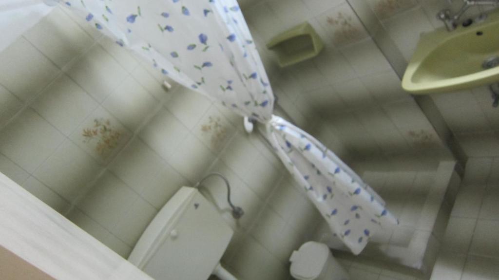 an umbrella in a bathroom with a toilet at Sandalis Hotel in Pythagoreio
