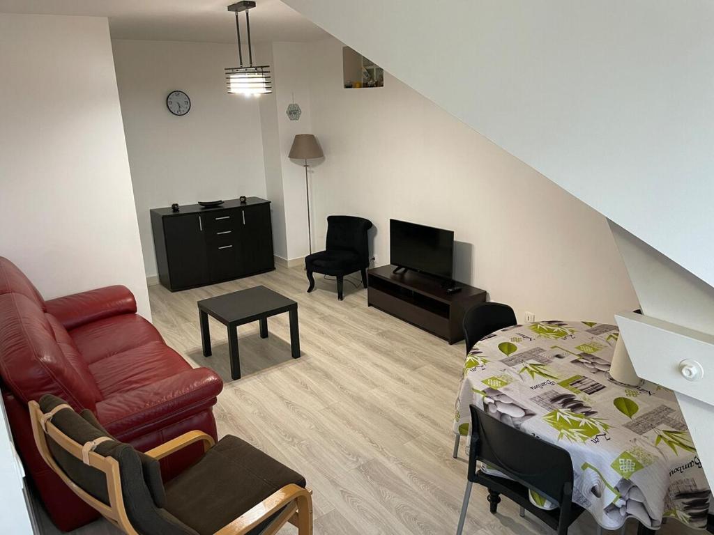 - un salon avec un lit, un canapé et une télévision dans l'établissement Floor of a house apartment F3, à Cormeilles-en-Parisis