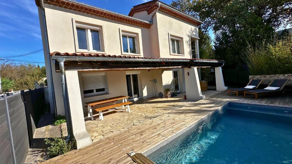 une maison avec une piscine devant une maison dans l'établissement La Villa des Rosiers, à Prades-le-Lez