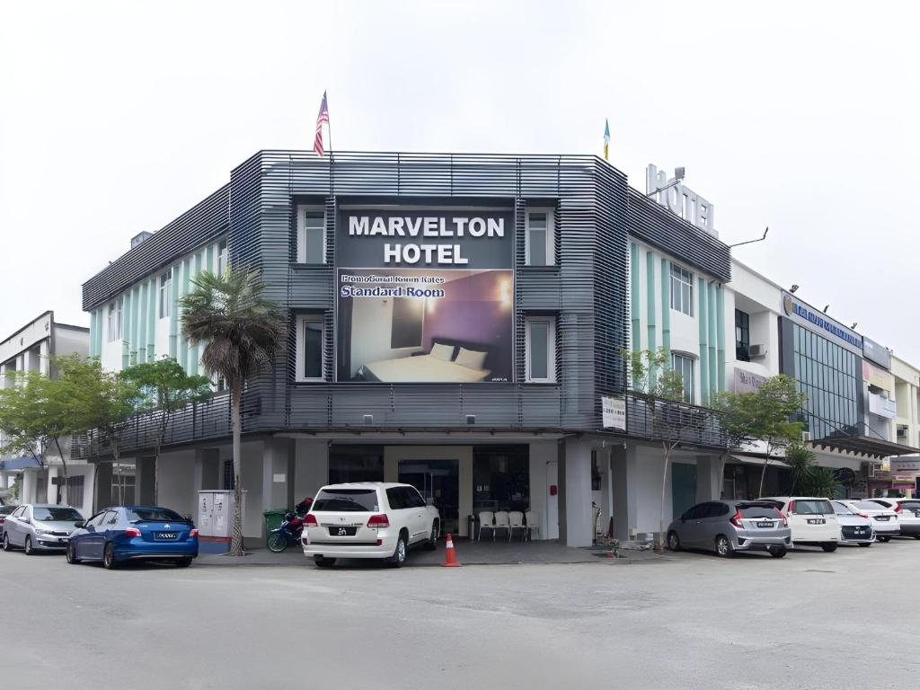 a hotel with cars parked in a parking lot at Hotel O Marvelton Hotel in Butterworth