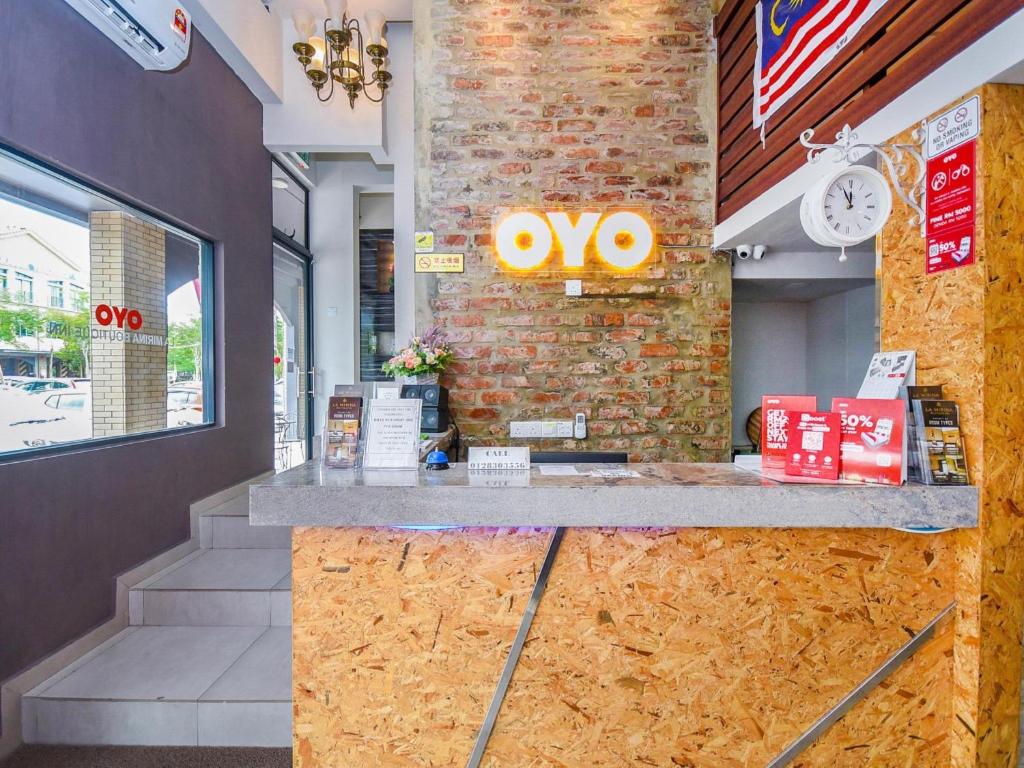 a store counter with an oo sign on a brick wall at Hotel O La Mirina Boutique Inn in Miri