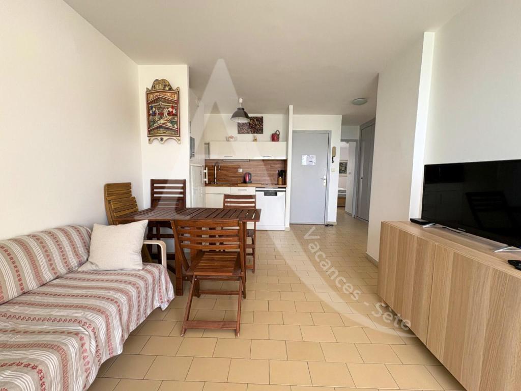 un salon avec un canapé et une table dans l'établissement 6 PERS, 2 CHAMBRES, DERNIER ETAGE EN FRONT DE MER, à Sète