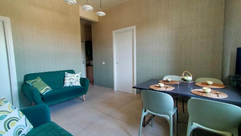 a living room with a table and chairs and a couch at Appartamento trilocale FRONTE MARE con SPIAGGIA INCLUSA Taunus vacanze cod 494 in Marcelli