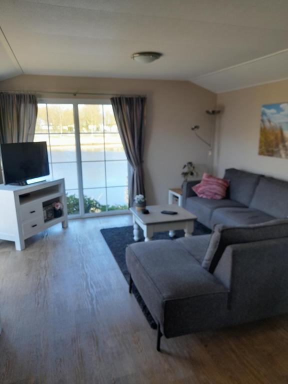 TV a/nebo společenská místnost v ubytování Chalet Makkum C99B met prive gelegen tuin aan het water