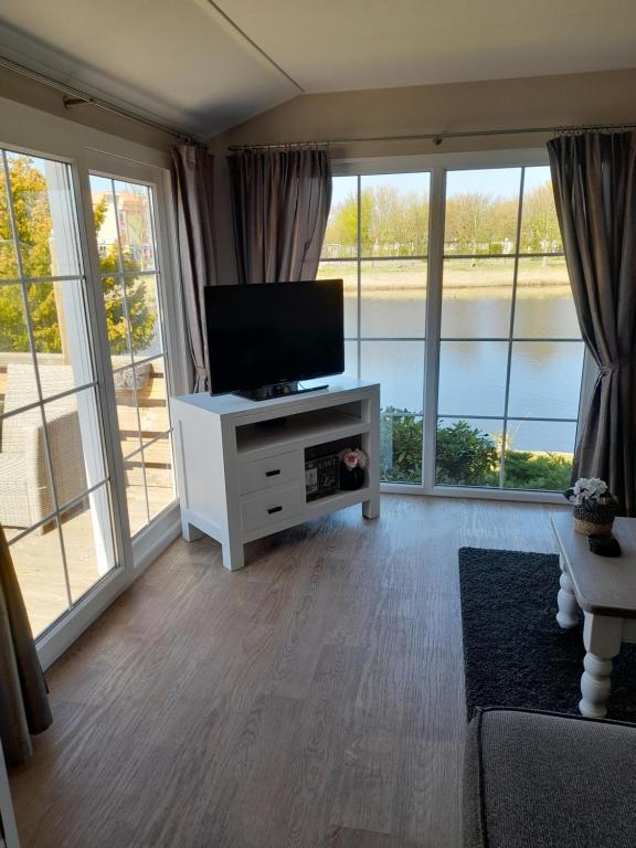 TV a/nebo společenská místnost v ubytování Chalet Makkum C99B met prive gelegen tuin aan het water