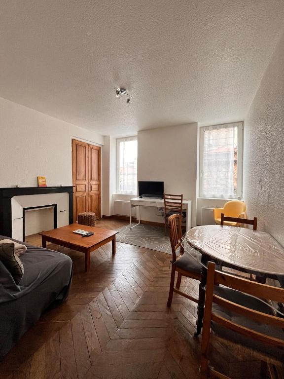 - un salon avec un lit, une table et un bureau dans l'établissement Logement chaleureux à 2 pas de la cathédrale, à Clermont-Ferrand