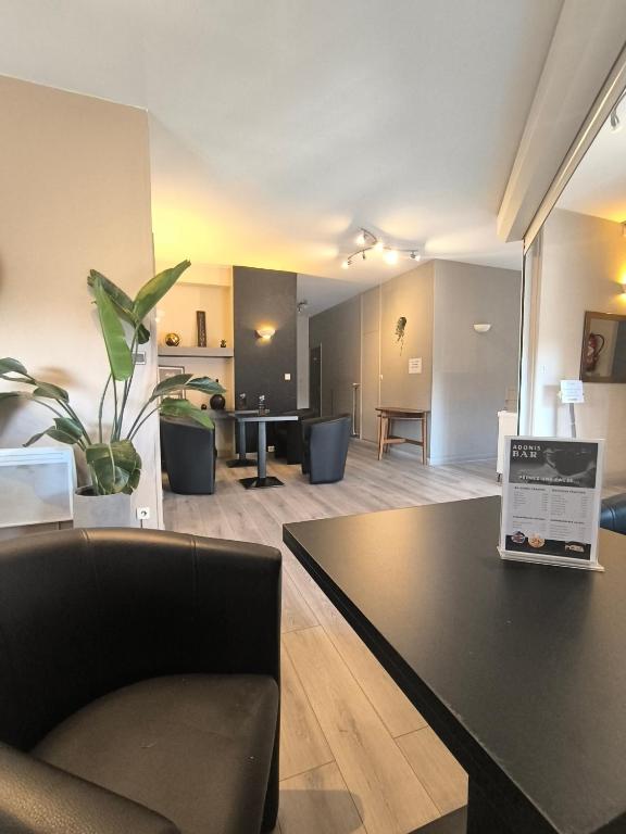 un salon avec un canapé et une table dans l'établissement Adonis Lyon Est Hôtel Artys, à Saint-Priest