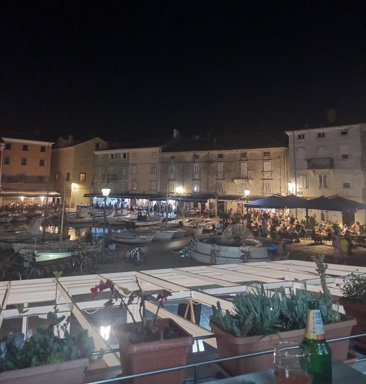a group of people sitting around a courtyard at night at Room No stress on Cres in Cres