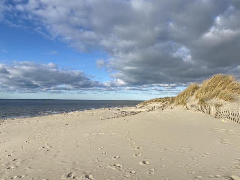 une plage de sable avec des empreintes sur le sable et l'océan dans l'établissement Charmant Studio Rêves de Mer 101, à Fort-Mahon-Plage