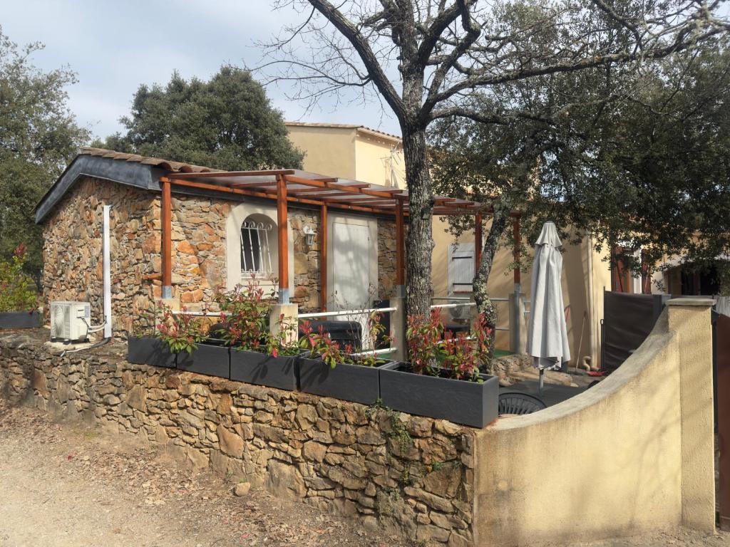 ein Haus mit einer Steinmauer und einem Zaun in der Unterkunft votre Cocon en pierre et son spa en option gîte le repos des chênes in Régusse