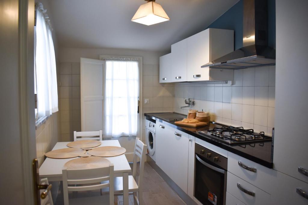 a kitchen with a small table and a kitchen with white cabinets at Renovated house 400 meters from the sea with parking in Forte dei Marmi