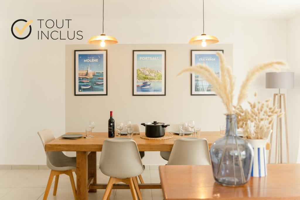 a dining room with a wooden table and chairs at TY KAER - Charmante maison neuve tout confort in Landunvez