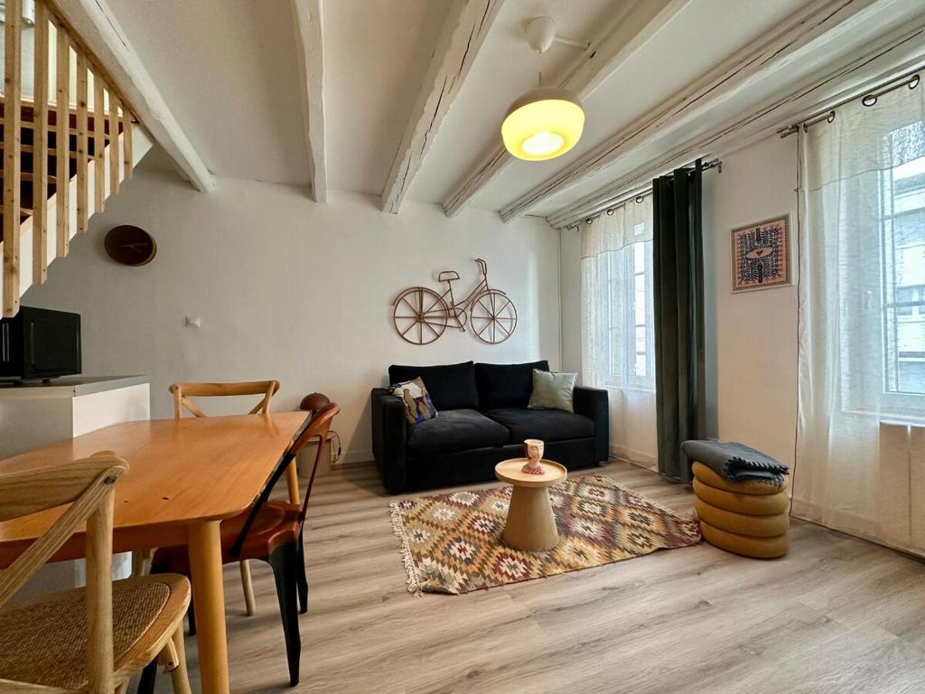 un salon avec un canapé noir et une table dans l'établissement Le Bohème - Duplex - 2 à 4 personnes - Proche Gare, à Nancy