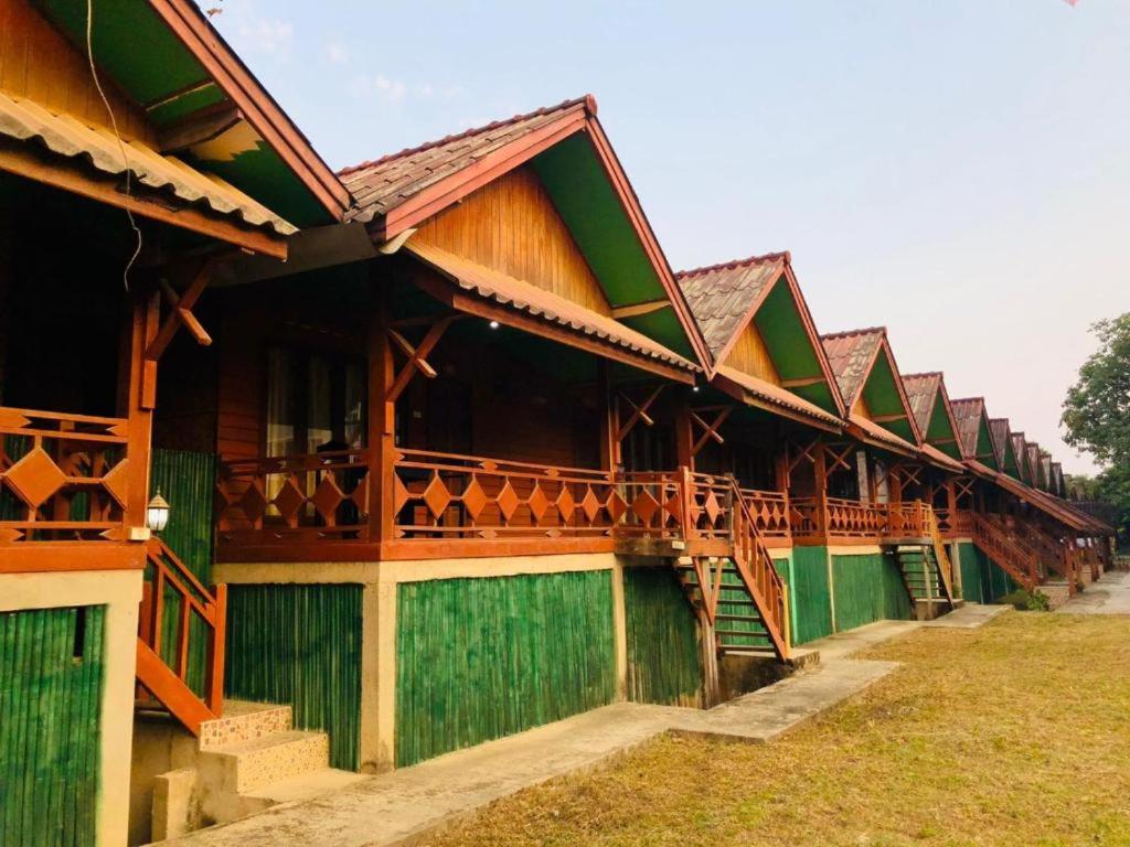 a building with green and brown at Bungalows Le Jardin VANGVIENG in Vang Vieng