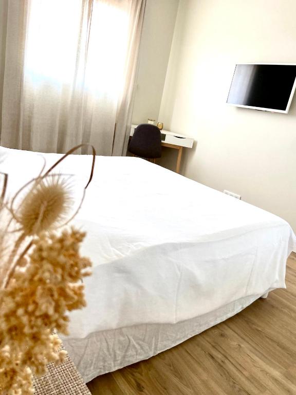 un lit blanc dans une chambre avec une fenêtre dans l'établissement Belle maison T4 au calme - Jardin & Parking, à Tournefeuille