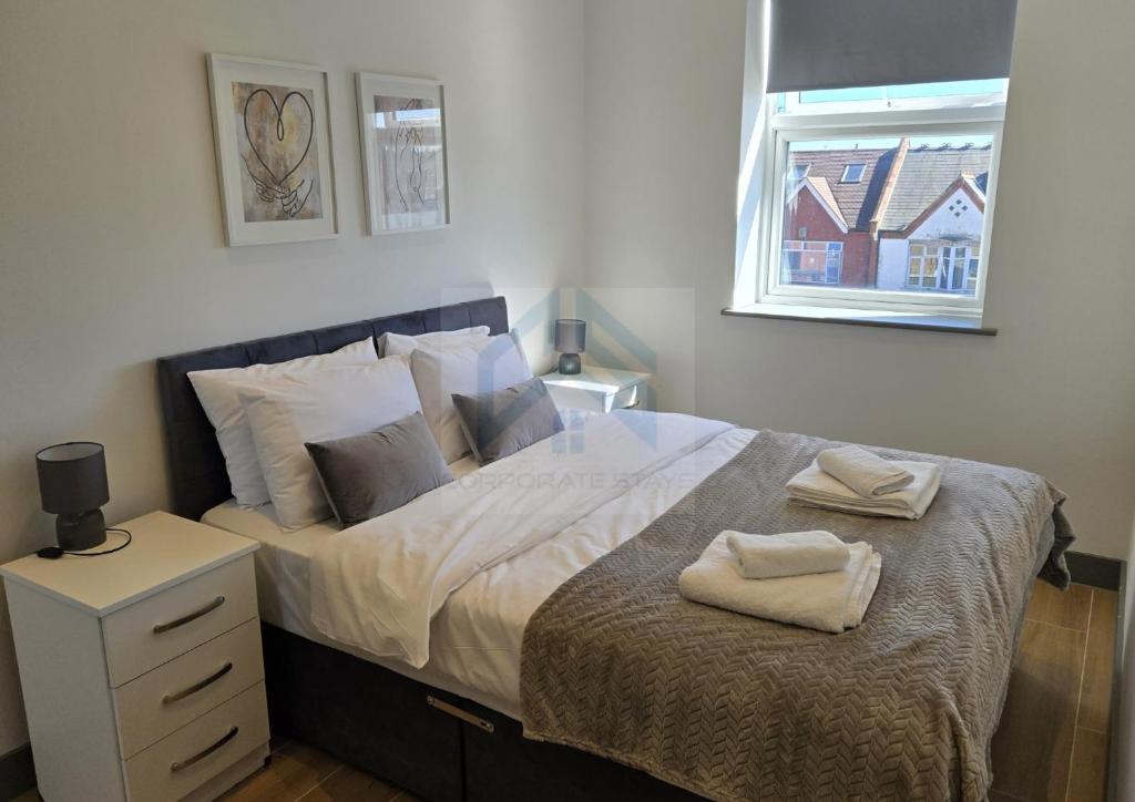 ein Schlafzimmer mit einem Bett mit zwei Handtüchern darauf in der Unterkunft Bright Finchley Apartments - Perfect for Business & Leisure in Finchley
