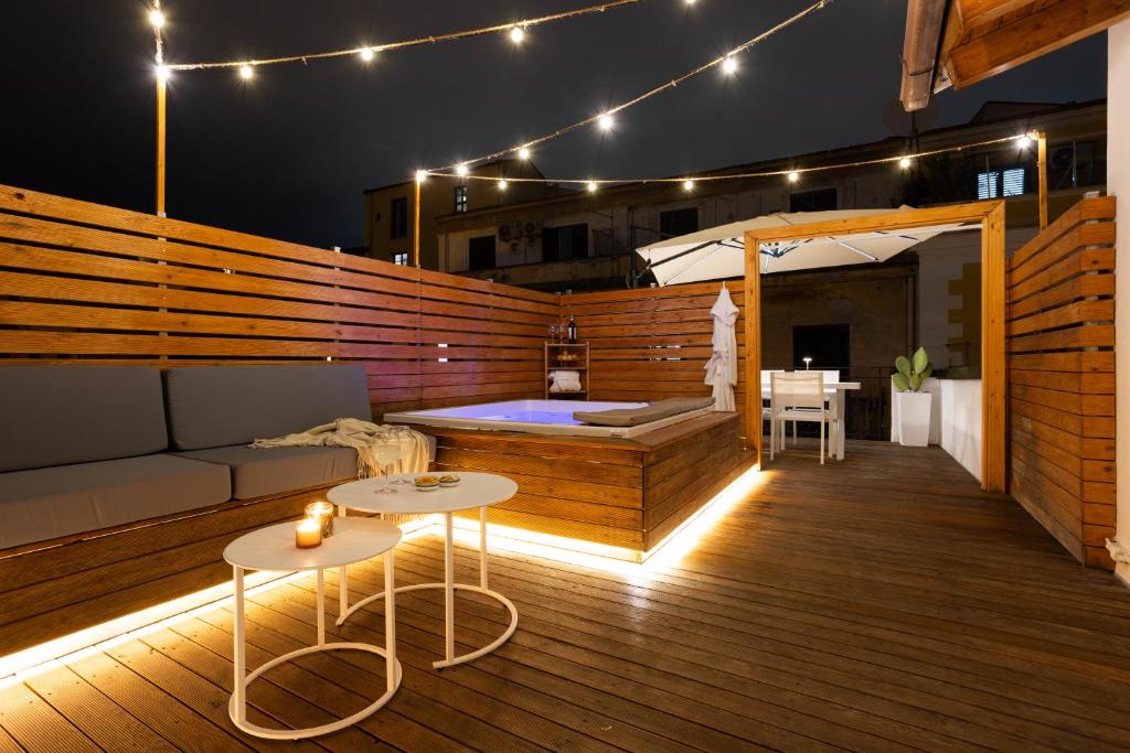 a rooftop deck with a hot tub and tables and lights at Le Terrazze dei Candelai "boutique apartments" in Palermo