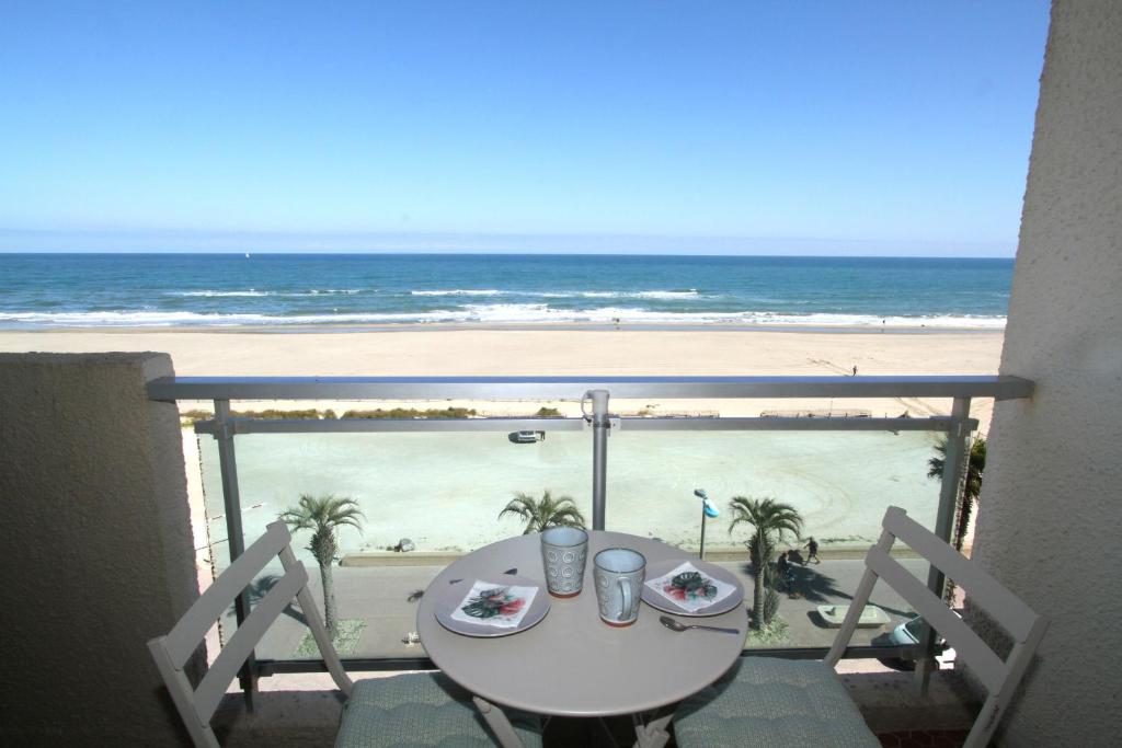 une table sur un balcon avec vue sur la plage dans l'établissement magnifique studio vue mer, à Canet