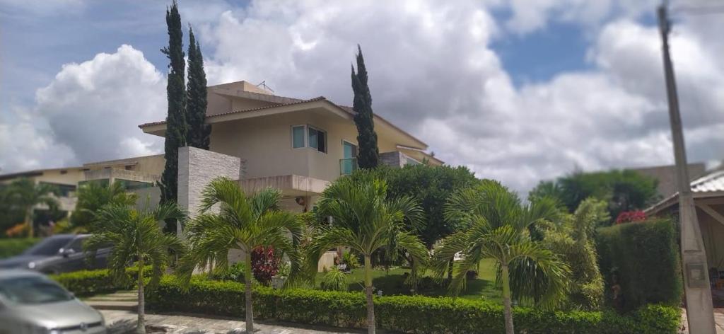 a house with palm trees in front of it at Casa para locação por temporada, Gravatá, Pernambuco in Gravatá