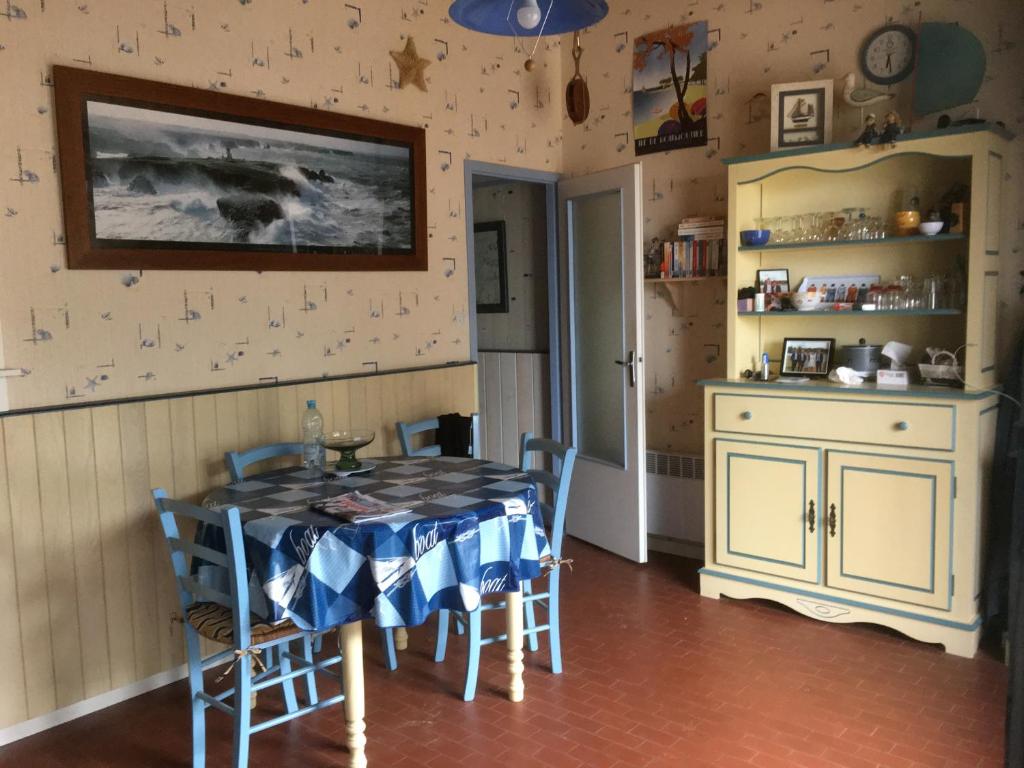 une cuisine avec une table et des chaises dans une pièce dans l'établissement maison latéral mer, à La Barre-de-Monts