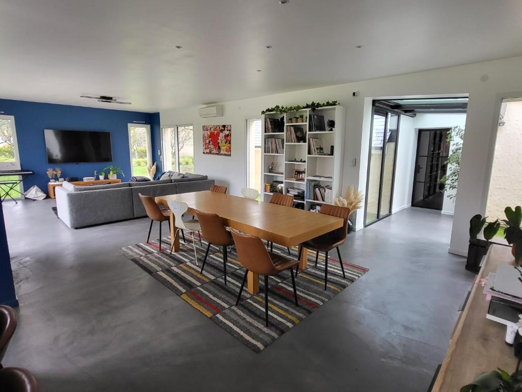 un salon avec une table et des chaises en bois dans l'établissement Maison moderne 180 m2, à 10 min du Circuit des 24h du Mans, à Fatines