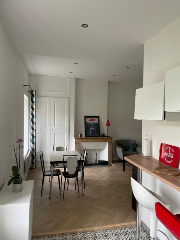 une cuisine et un salon avec une table et des chaises dans l'établissement Appartement collonges bord de Saône, à Collonges-au-Mont-dʼOr