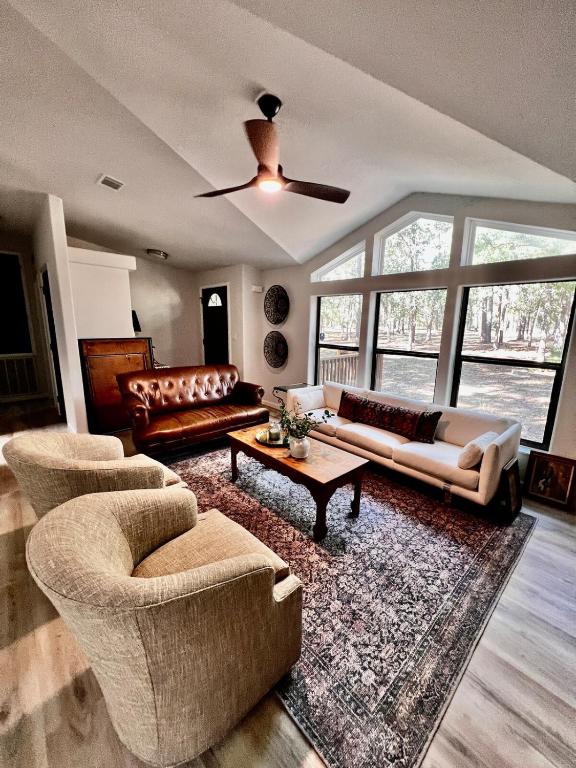 a living room with couches and a couch and a table at The Pine Tree Palace in Bastrop