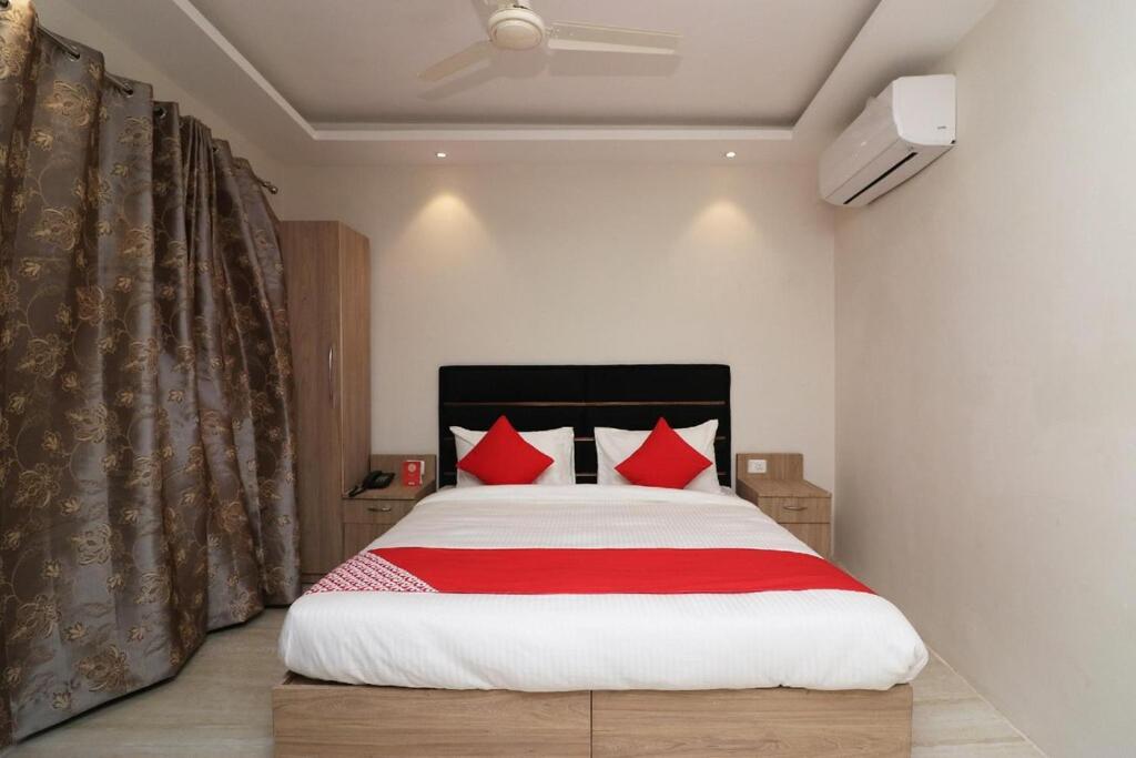 a bedroom with a large bed with red pillows at Grace Residency in Puducherry Airpoert