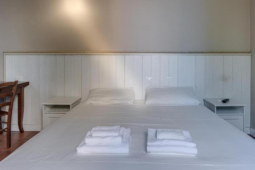 a bedroom with a large white bed with towels on it at DUE TORRI 1 LUXURY PALACE- BEDINBOLOGNAcentro in Bologna