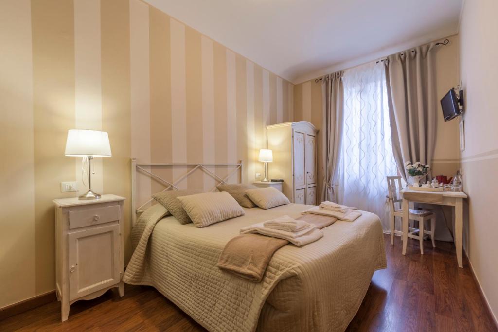 1 dormitorio con cama, mesa y escritorio en Soggiorno Pezzati, en Florencia