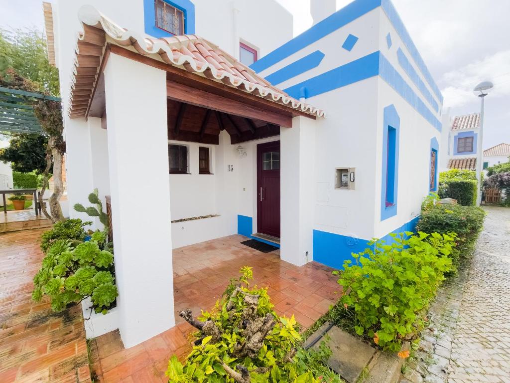 een wit en blauw huis met een rode deur bij Villa Dunn Mar V3 by YHA in Cabanas de Tavira