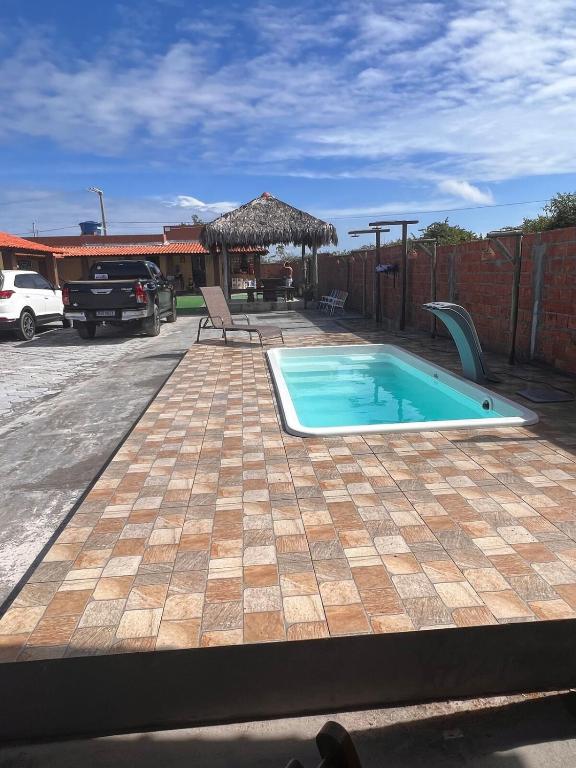 a swimming pool in a yard with a patio at Vila Lençóis Residence in Santo Amaro