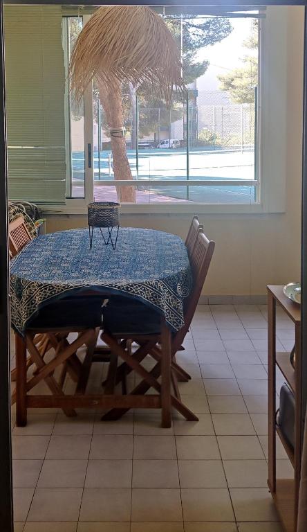 une table dans une pièce avec un palmier dans l'établissement T2 Plage la corniche, les Tennis de castelmare à Sète appartement classé 3 etoiles, à Sète