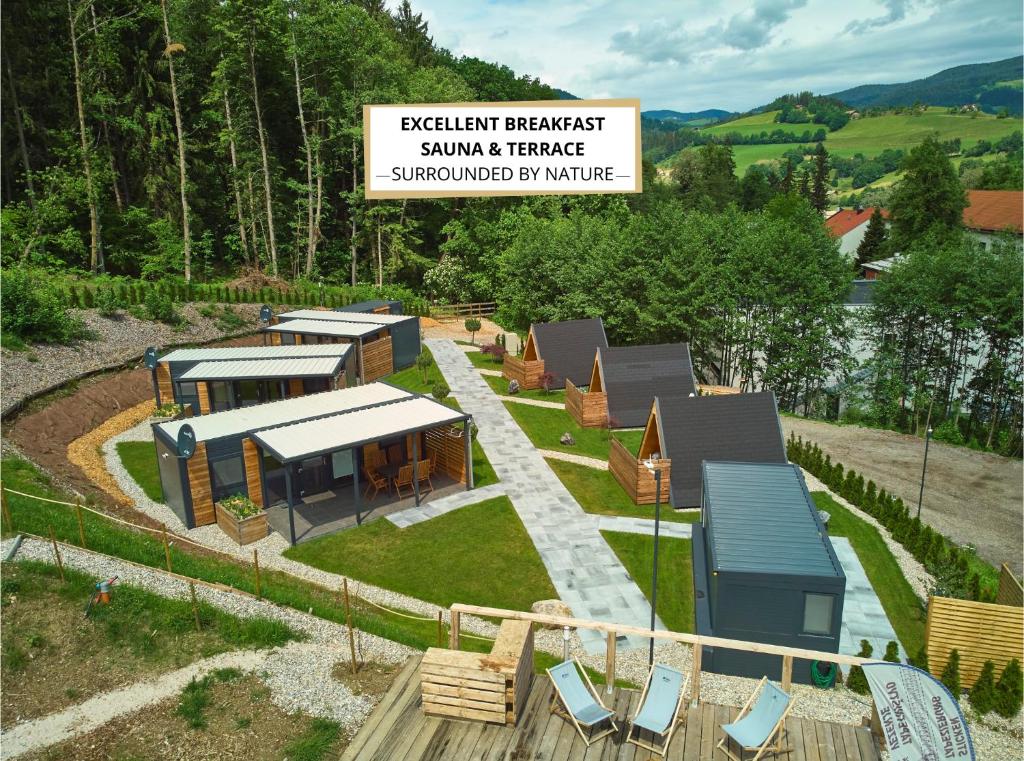 a model of a house with chairs and a sign at Natura Fina Resort in Ravne na Koroškem
