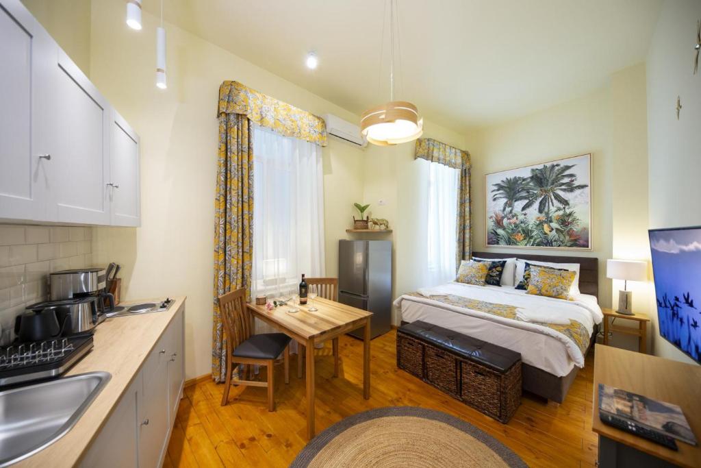 a bedroom with a bed and a kitchen with a table at Rainforest Studio Downtown by Pretty Apartments in Bucharest