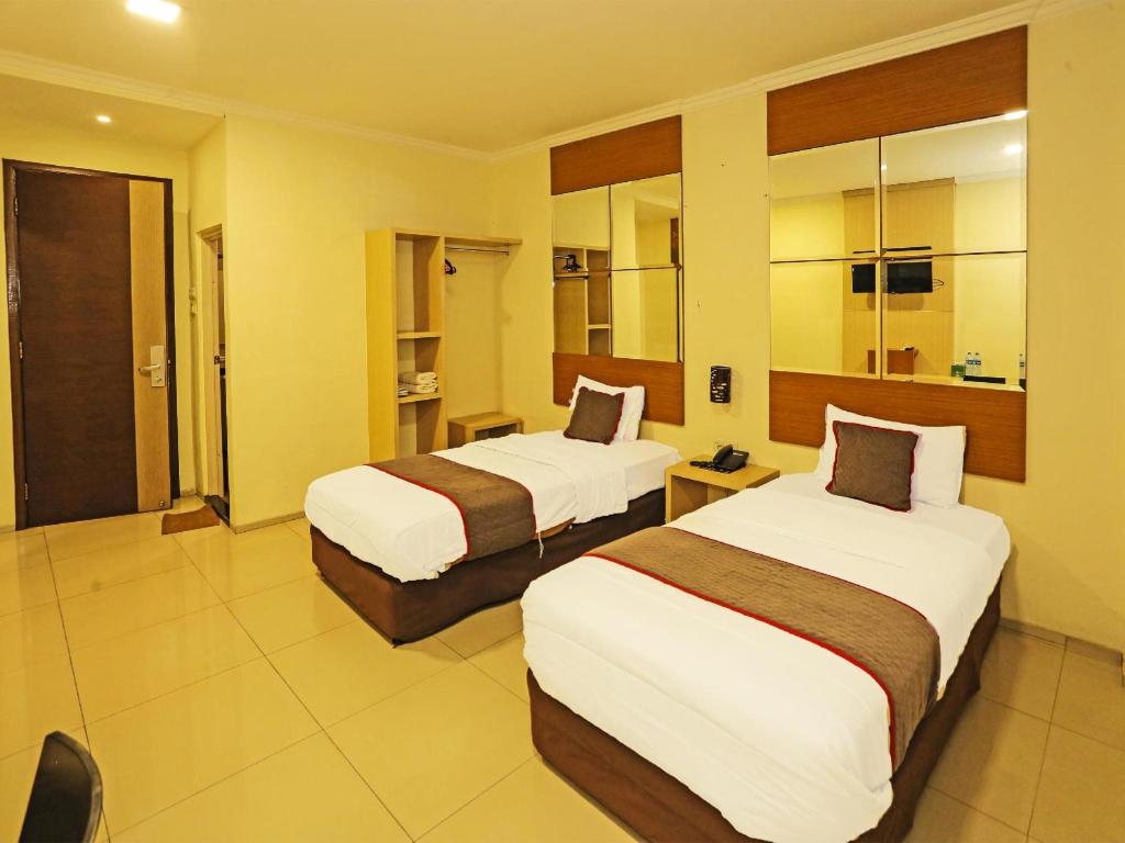 Postel nebo postele na pokoji v ubytování Super OYO Townhouse OAK Hotel Fiducia Serpong
